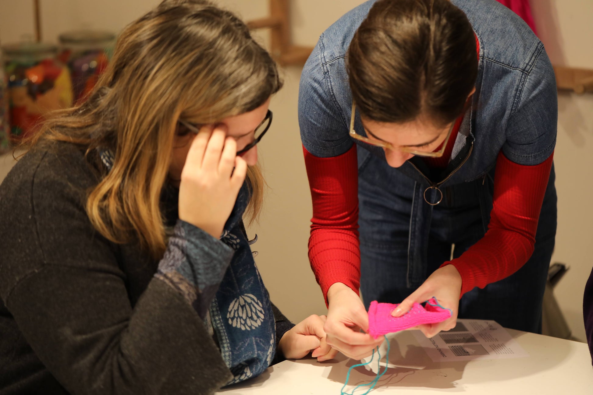 Socko founder Emma teaching a student to darn one to one